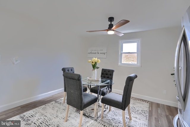 dining space with ceiling fan, baseboards, and wood finished floors