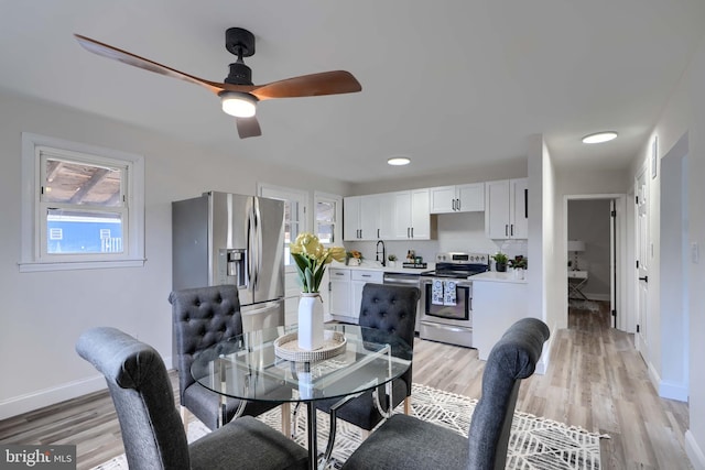 dining room with ceiling fan, light wood-type flooring, and baseboards