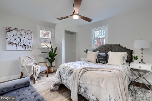 bedroom featuring ceiling fan, baseboards, and wood finished floors