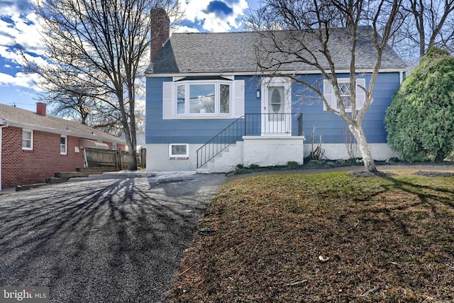 view of front of house featuring a chimney and a shingled roof