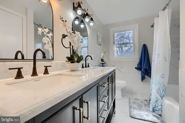 full bathroom featuring a sink, toilet, marble finish floor, and double vanity