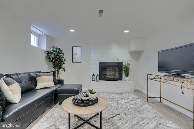 living room with recessed lighting, a fireplace, baseboards, and wood finished floors