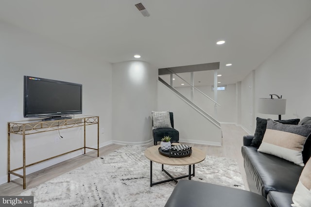 living room with visible vents, recessed lighting, and wood finished floors