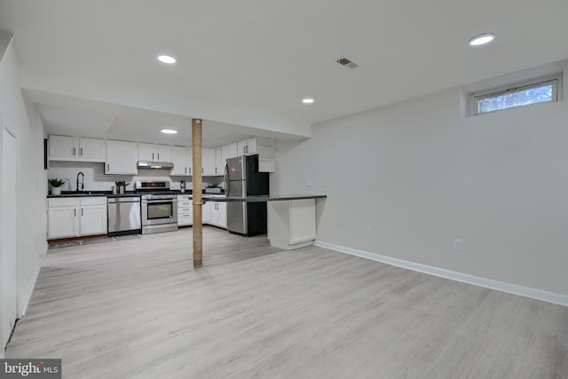 kitchen featuring a sink, stainless steel appliances, dark countertops, and visible vents