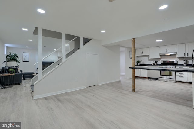 living area with recessed lighting, stairway, and light wood finished floors