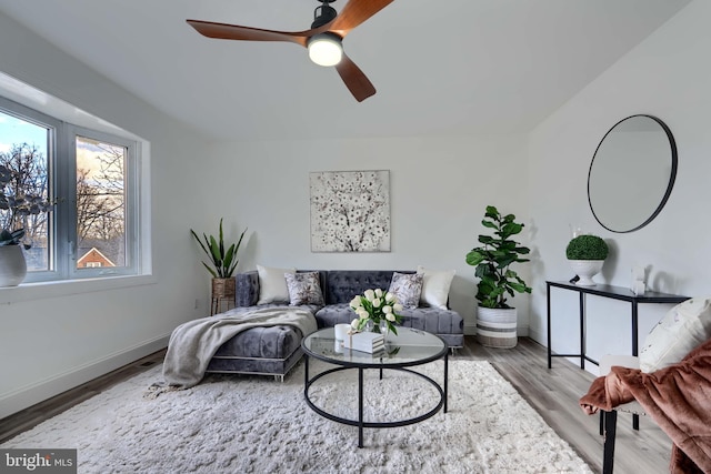 living room featuring wood finished floors, baseboards, and ceiling fan