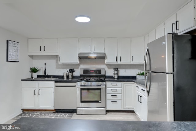 kitchen featuring under cabinet range hood, decorative backsplash, white cabinets, and stainless steel appliances