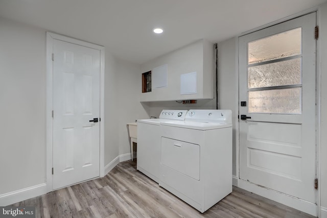 laundry area with baseboards, light wood-style floors, laundry area, and washer and clothes dryer