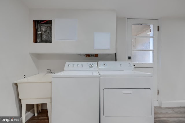 clothes washing area with baseboards, independent washer and dryer, wood finished floors, and laundry area