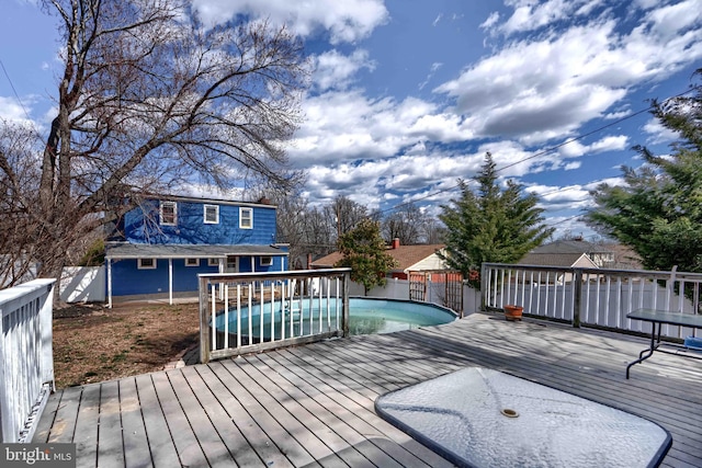 wooden deck with a fenced in pool and fence