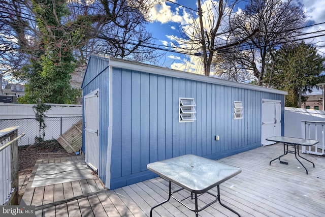 deck with an outdoor structure and fence