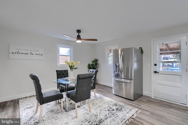 dining space featuring baseboards, light wood-style floors, and a ceiling fan