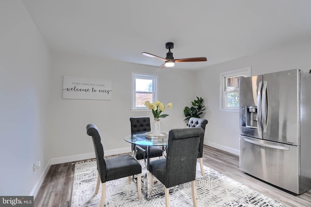 dining area with ceiling fan, light wood-type flooring, and baseboards