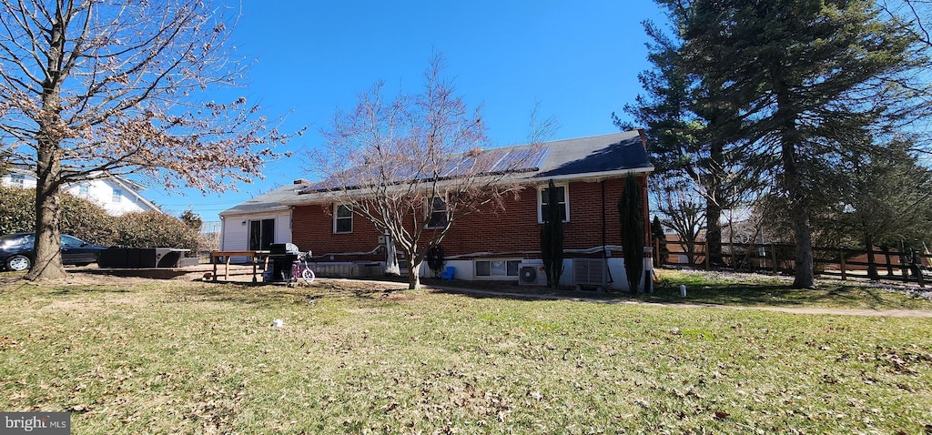 back of house with entry steps and a yard