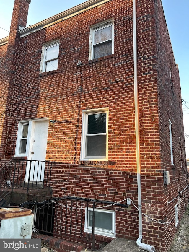 view of side of home with brick siding and a chimney