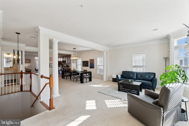 living room with light colored carpet, baseboards, an inviting chandelier, and decorative columns