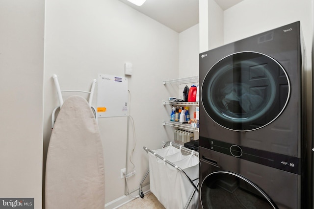 laundry area with light tile patterned flooring, laundry area, and stacked washer / dryer