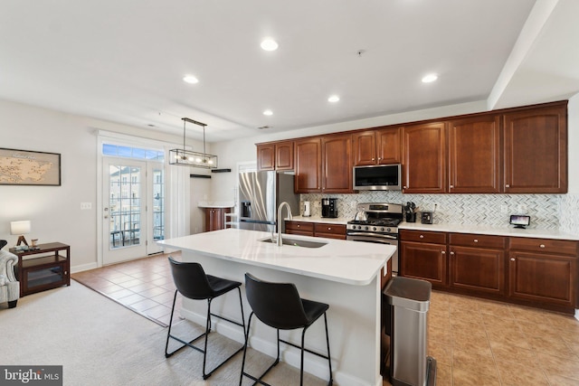 kitchen with a breakfast bar, a sink, backsplash, stainless steel appliances, and light countertops