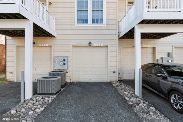 garage with aphalt driveway and central air condition unit