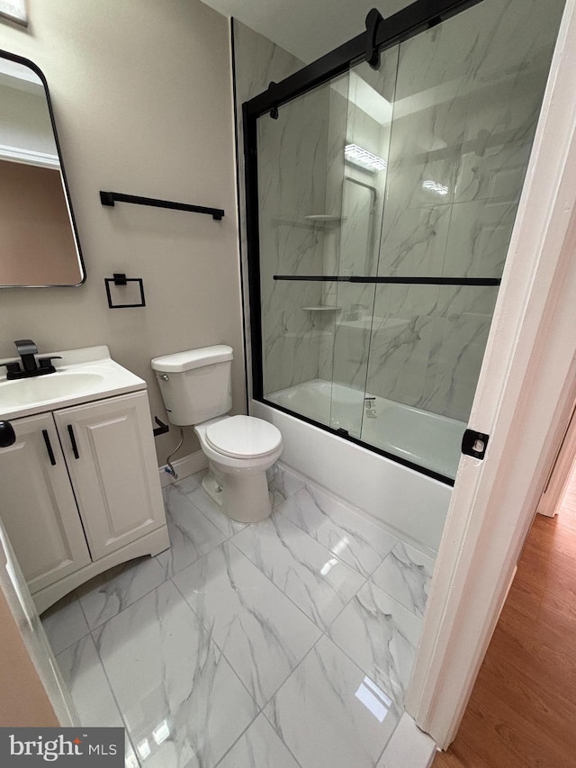 full bathroom with baseboards, toilet, enclosed tub / shower combo, marble finish floor, and vanity