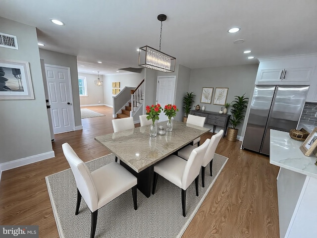 dining room featuring dark wood finished floors, stairway, recessed lighting, and visible vents