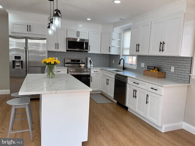 kitchen with a sink, open shelves, a center island, appliances with stainless steel finishes, and light wood finished floors