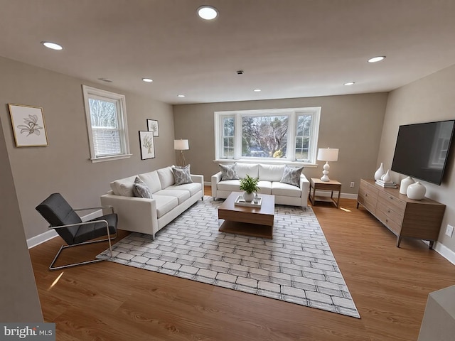 living area featuring recessed lighting, baseboards, plenty of natural light, and wood finished floors