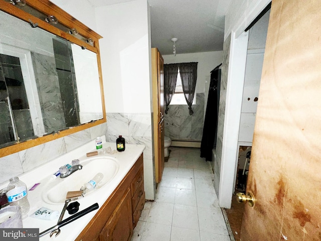 bathroom with vanity, tile walls, toilet, and wainscoting