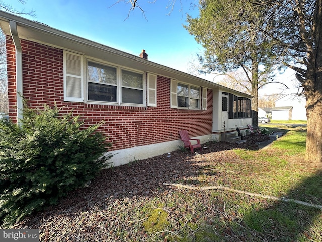 view of front of property featuring brick siding and a sunroom