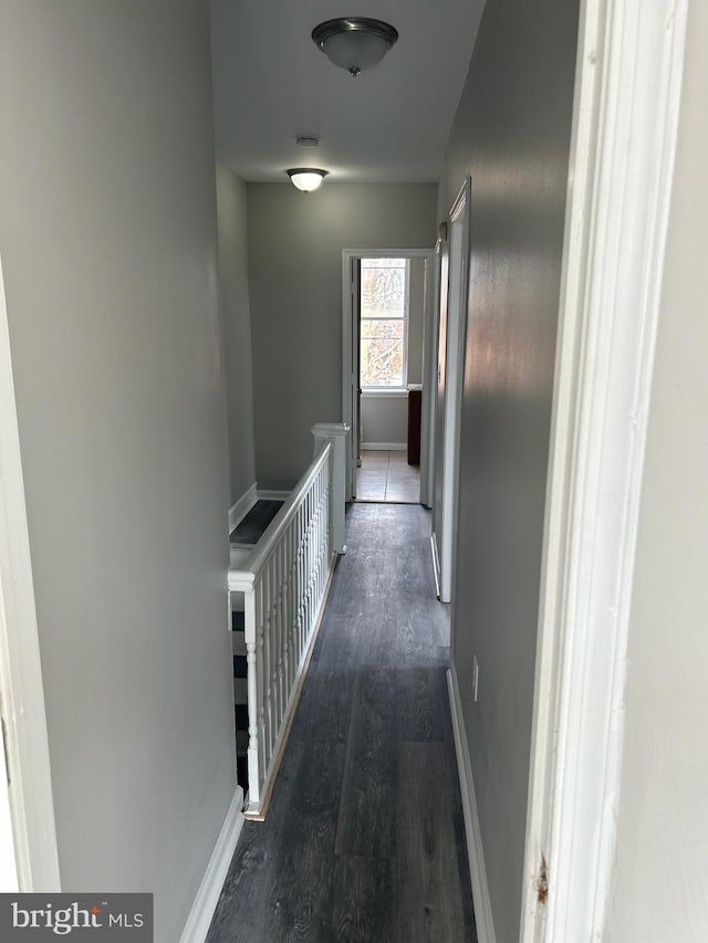 corridor featuring dark wood-style floors and baseboards