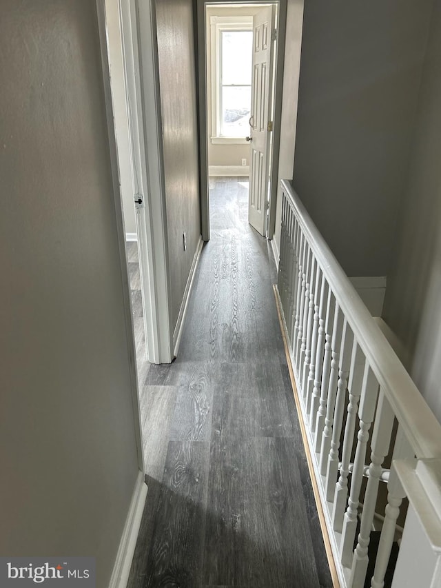 hall featuring baseboards and dark wood-style floors