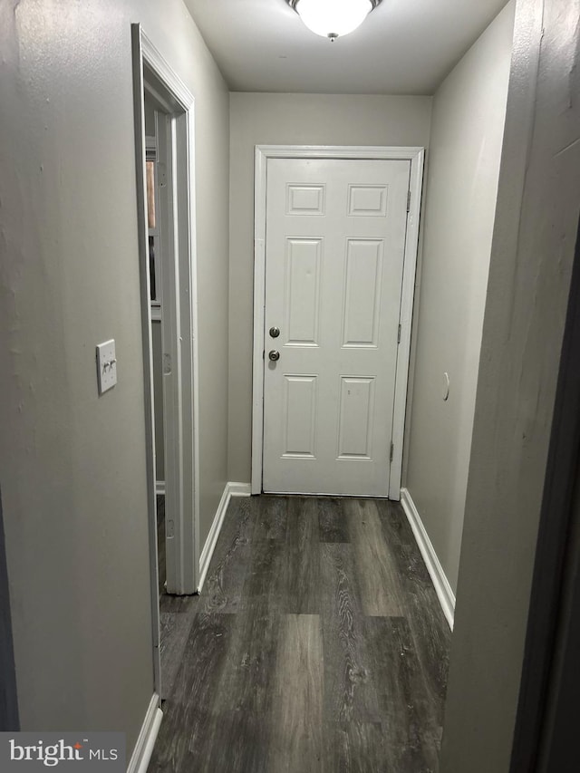 entryway featuring baseboards and dark wood-style flooring