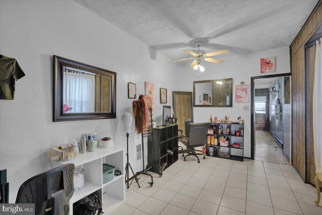 home office with light tile patterned floors and ceiling fan