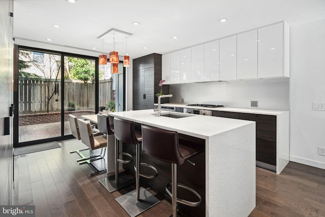 kitchen featuring a sink, modern cabinets, dark wood-style flooring, and white cabinetry