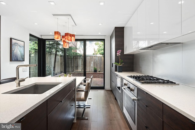 kitchen featuring a sink, dark brown cabinetry, white cabinets, appliances with stainless steel finishes, and modern cabinets