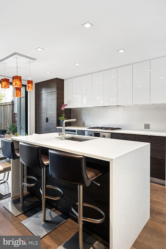 kitchen with a kitchen bar, dark wood-style floors, modern cabinets, and white cabinetry