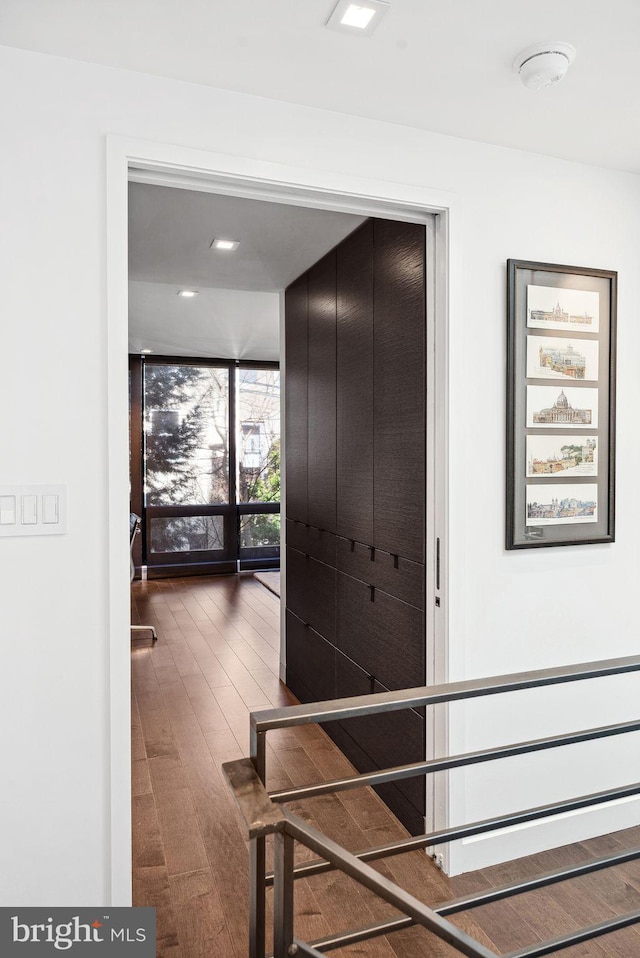 stairway with a wall of windows and wood finished floors