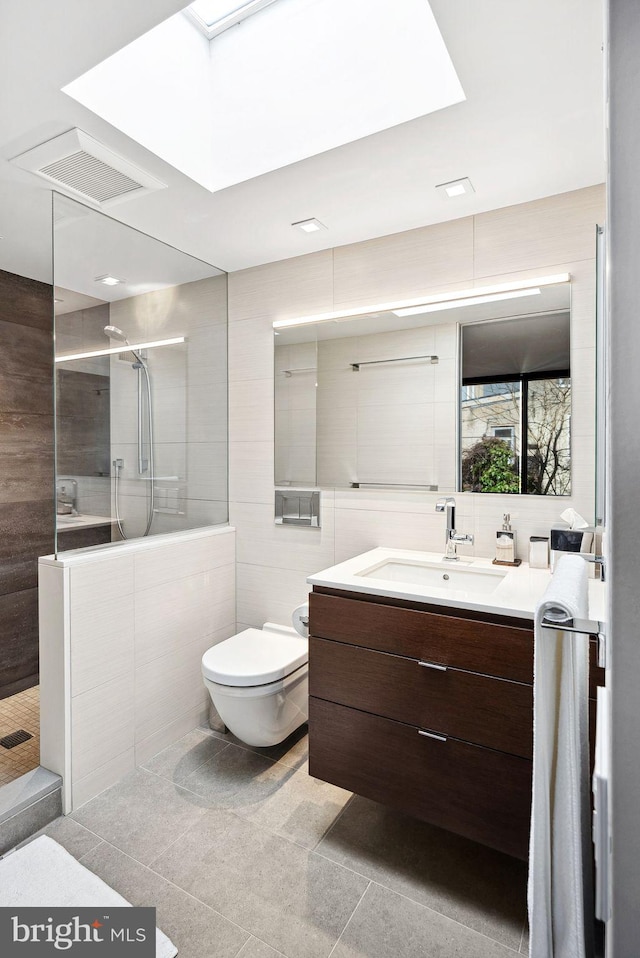 full bathroom featuring vanity, visible vents, a walk in shower, tile walls, and toilet