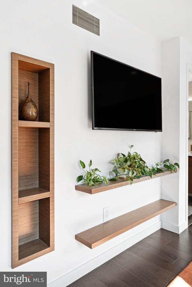 room details featuring visible vents, baseboards, and wood finished floors