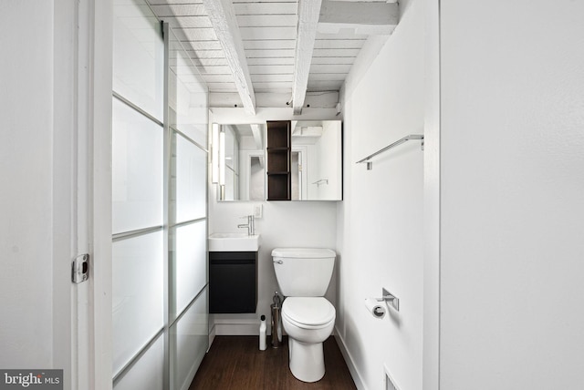 half bathroom with visible vents, baseboards, toilet, wood finished floors, and vanity