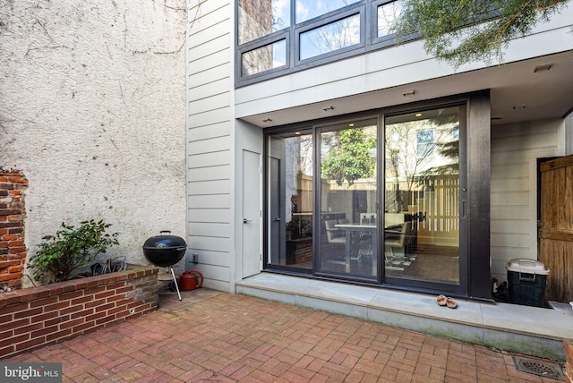 entrance to property featuring a patio and stucco siding