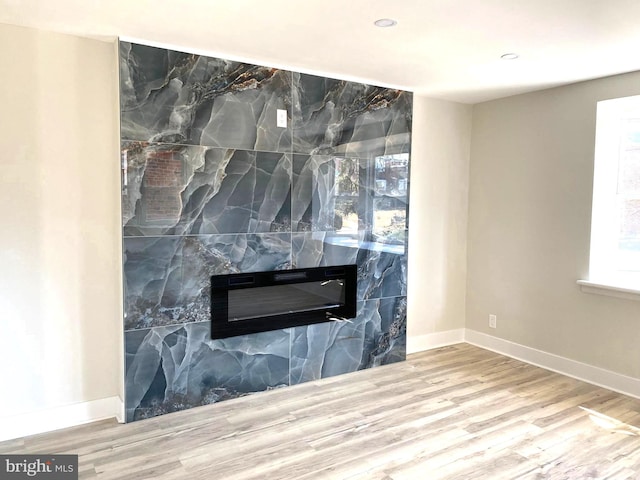 interior details with recessed lighting, a large fireplace, baseboards, and wood finished floors