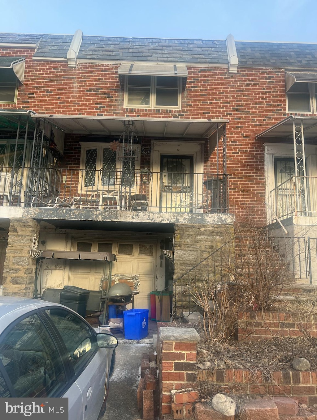 rear view of property featuring brick siding and a garage