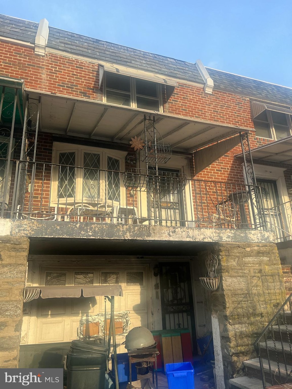 rear view of property featuring brick siding and a balcony