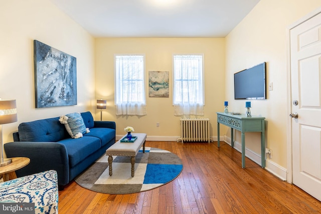 living room with radiator heating unit, baseboards, and hardwood / wood-style floors