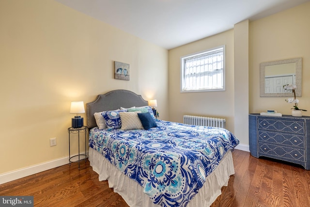 bedroom with baseboards, radiator, and wood finished floors