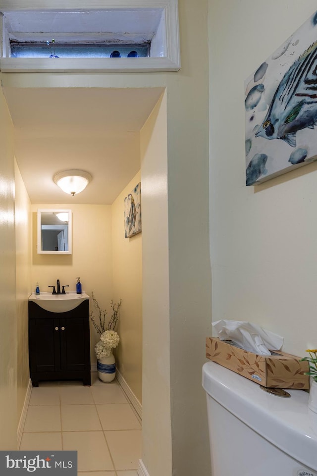 bathroom with tile patterned flooring, toilet, vanity, and baseboards