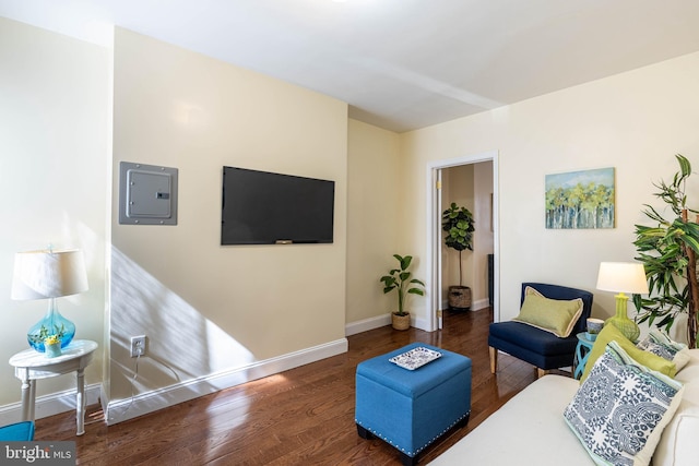 living room with electric panel, baseboards, and wood finished floors