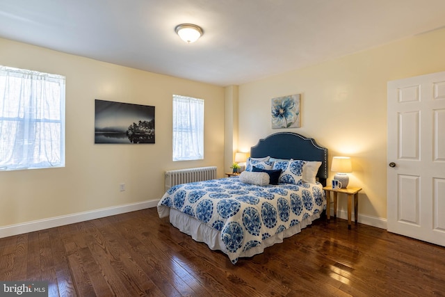 bedroom featuring radiator, wood finished floors, and baseboards