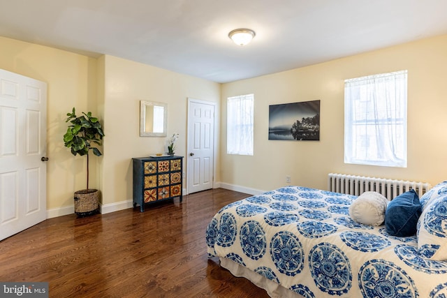 bedroom featuring baseboards, radiator, and wood finished floors